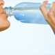 یک زن در حال نوشیدن آب از یک بطری