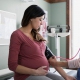 یک دکتر در حال اندازه گیری فشار خون یک زن باردار